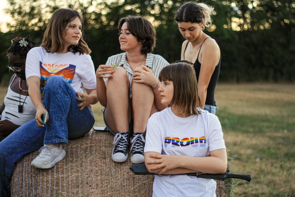 4 jeunes sont sur une botte de foin dans la nature