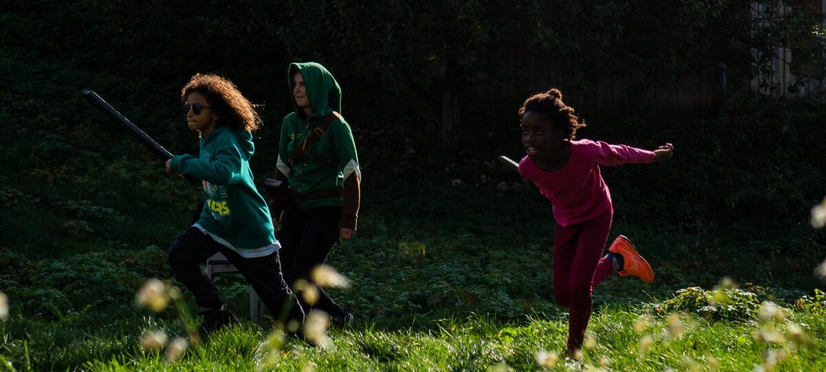 Groupe de jeunes participant à une colonie de vacances inclusive, assis en cercle dans un espace naturel verdoyant