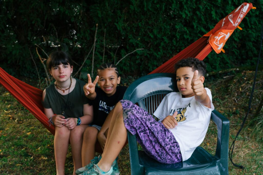 Trois jeunes sont dans un hamac lors de colonies de vacances inclusives