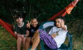 Trois jeunes sont dans un hamac lors de colonies de vacances inclusives