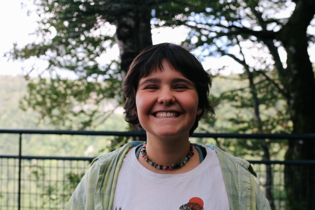 Une ado avec le sourire sur une colonie de vacances inclusive et écoresponsable organisée par Toustes en Colo Toustes en Colo