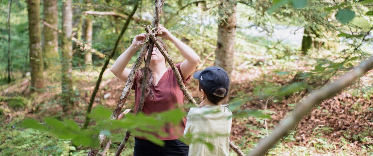 Anim et enfant fabriquant une cabane en colonie de vacances