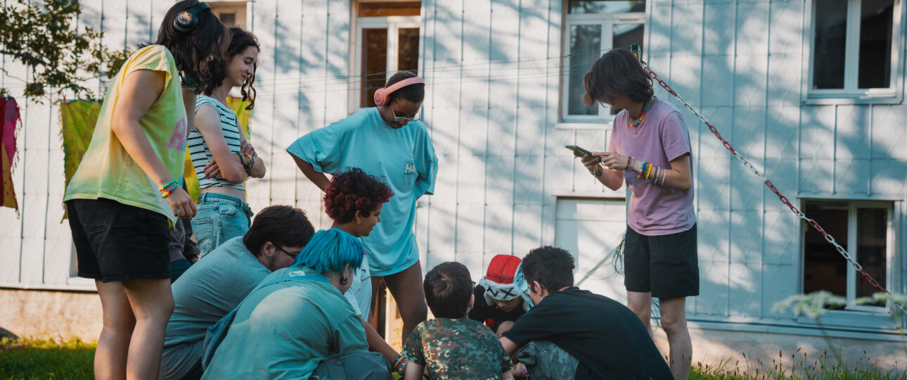 Groupe d'enfants et d'animateurs souriants en colonie de vacances inclusive dans le Jura avec Toustes en Colo