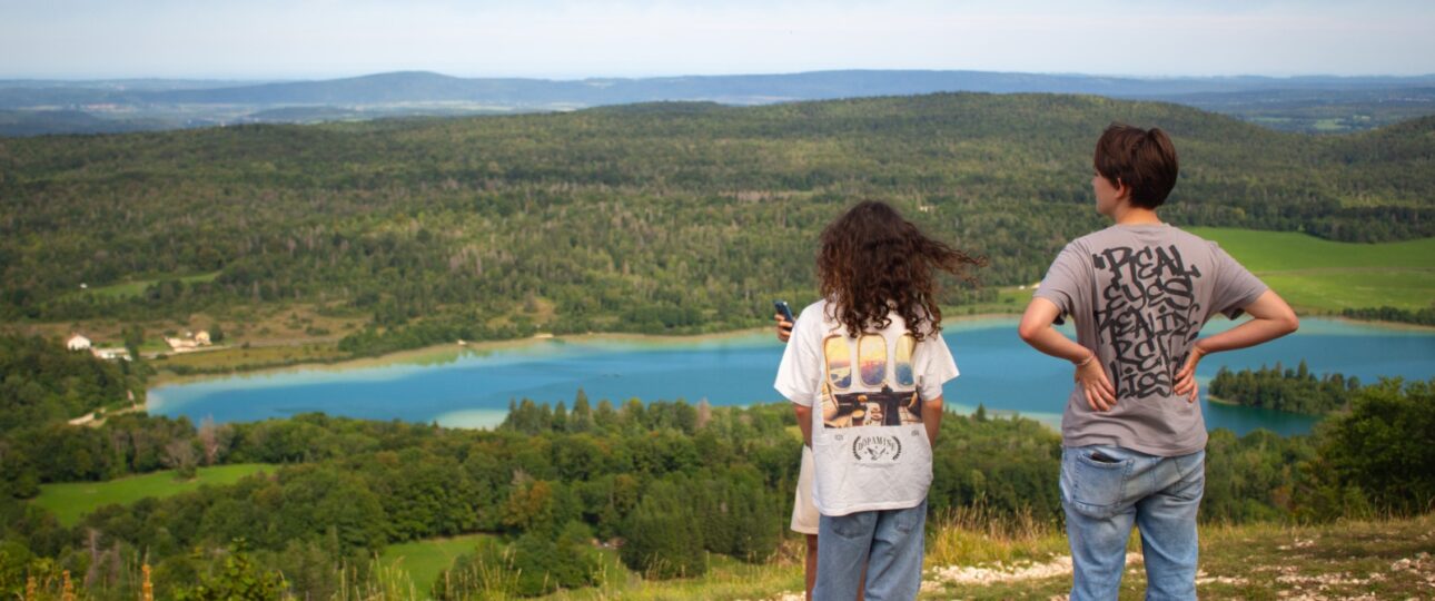 Groupe de jeunes en colonie de vacances écologique lors d'une balade dans les prairies du Jura