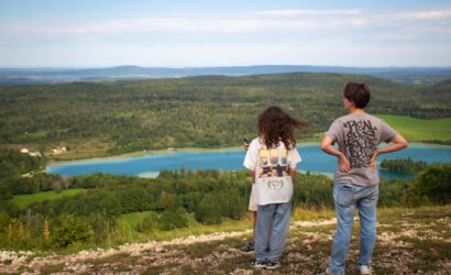 Groupe de jeunes en colonie de vacances écologique lors d'une balade dans les prairies du Jura