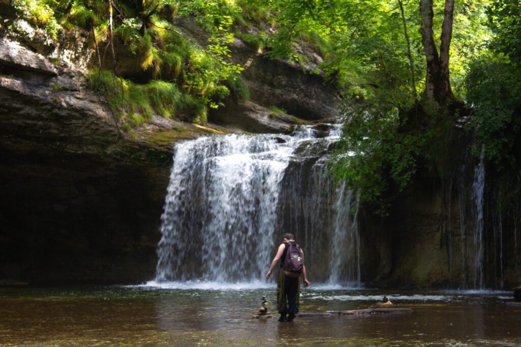 Ado devant les cascades du hérisson en colo