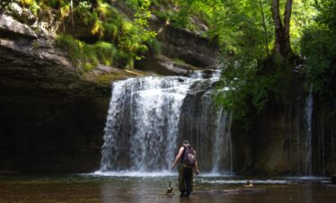 Ado devant les cascades du hérisson en colo