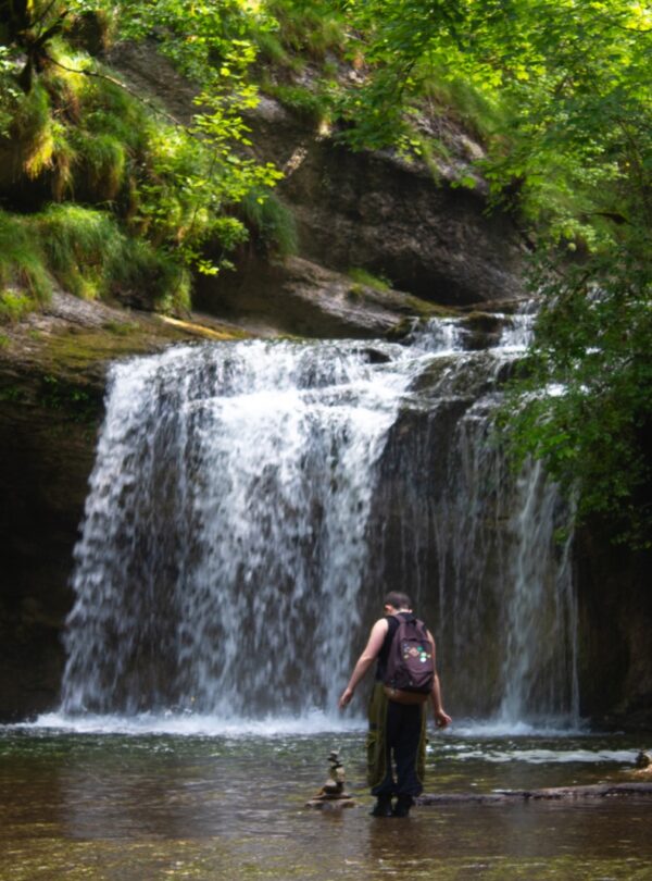 Ado devant les cascades du hérisson en colo