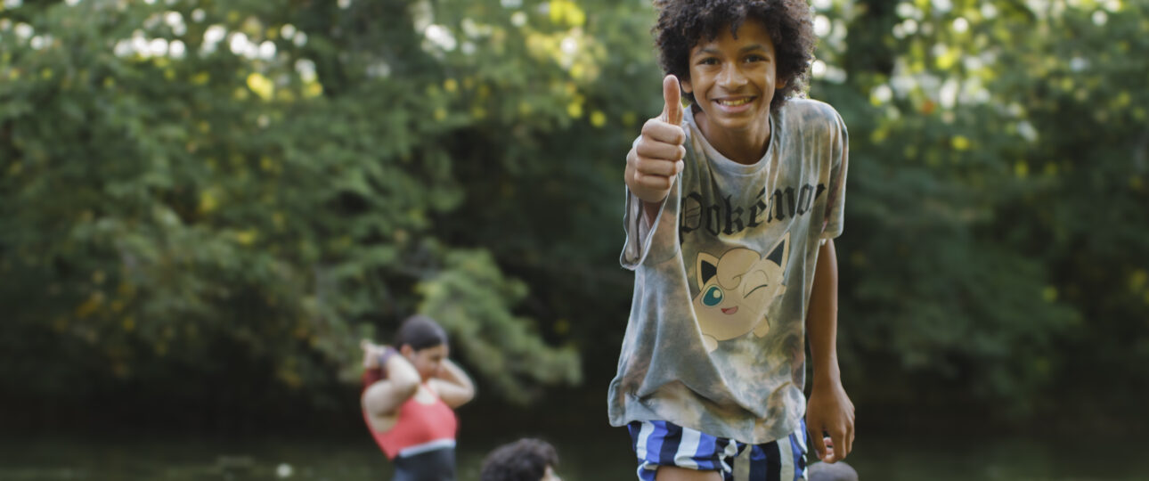 Groupe d'enfants et d'animateurs souriants en colonie de vacances inclusive dans le Jura avec Toustes en Colo